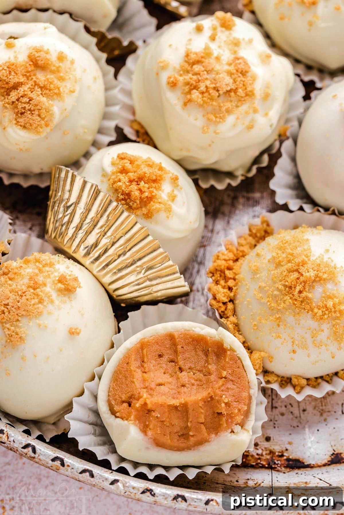Close-up of ginger truffles elegantly presented on a metal plate, cradled in gold liners. One of the truffles has a bite taken out, showcasing its delicious interior.