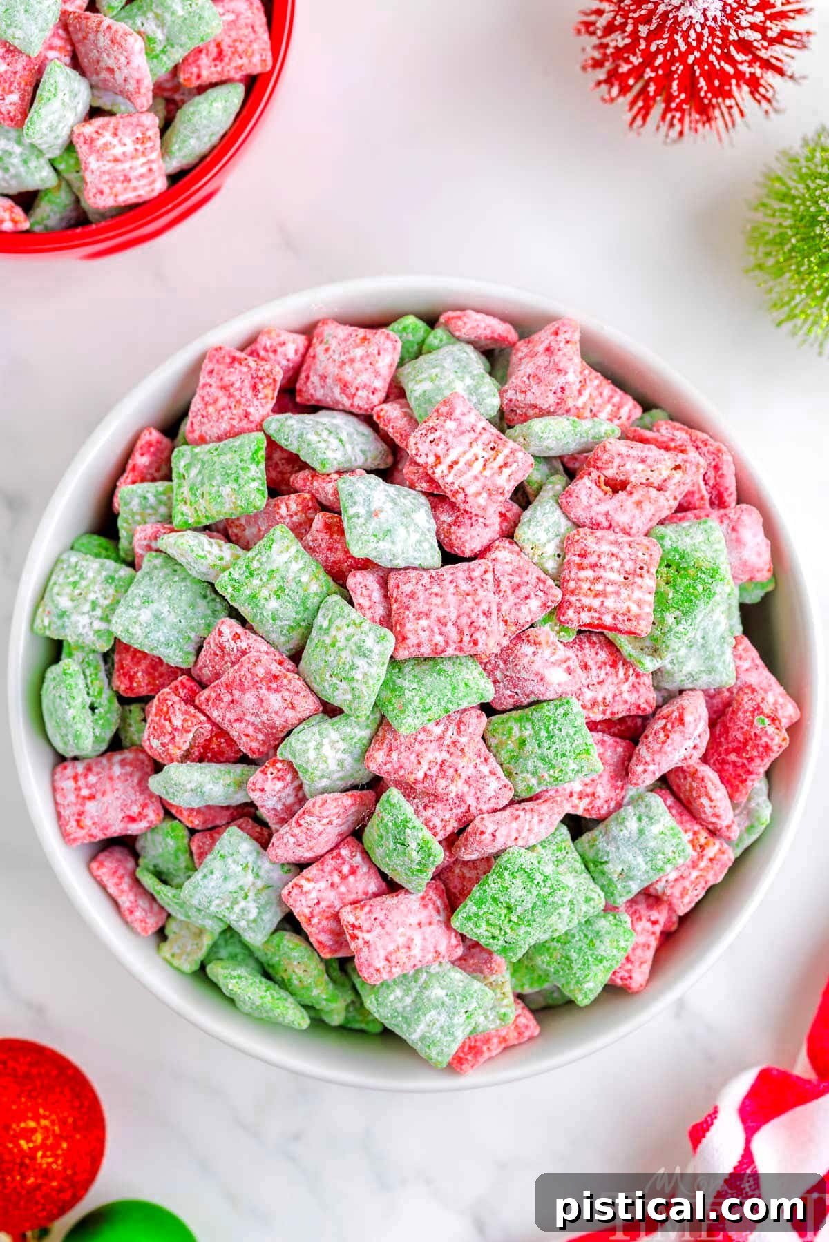 top down view of large white bowl filled with christmas muddy buddies made with red and green melts.