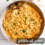 Top-down view of Bang Bang Shrimp Pasta in a large skillet, garnished with fresh parsley.
