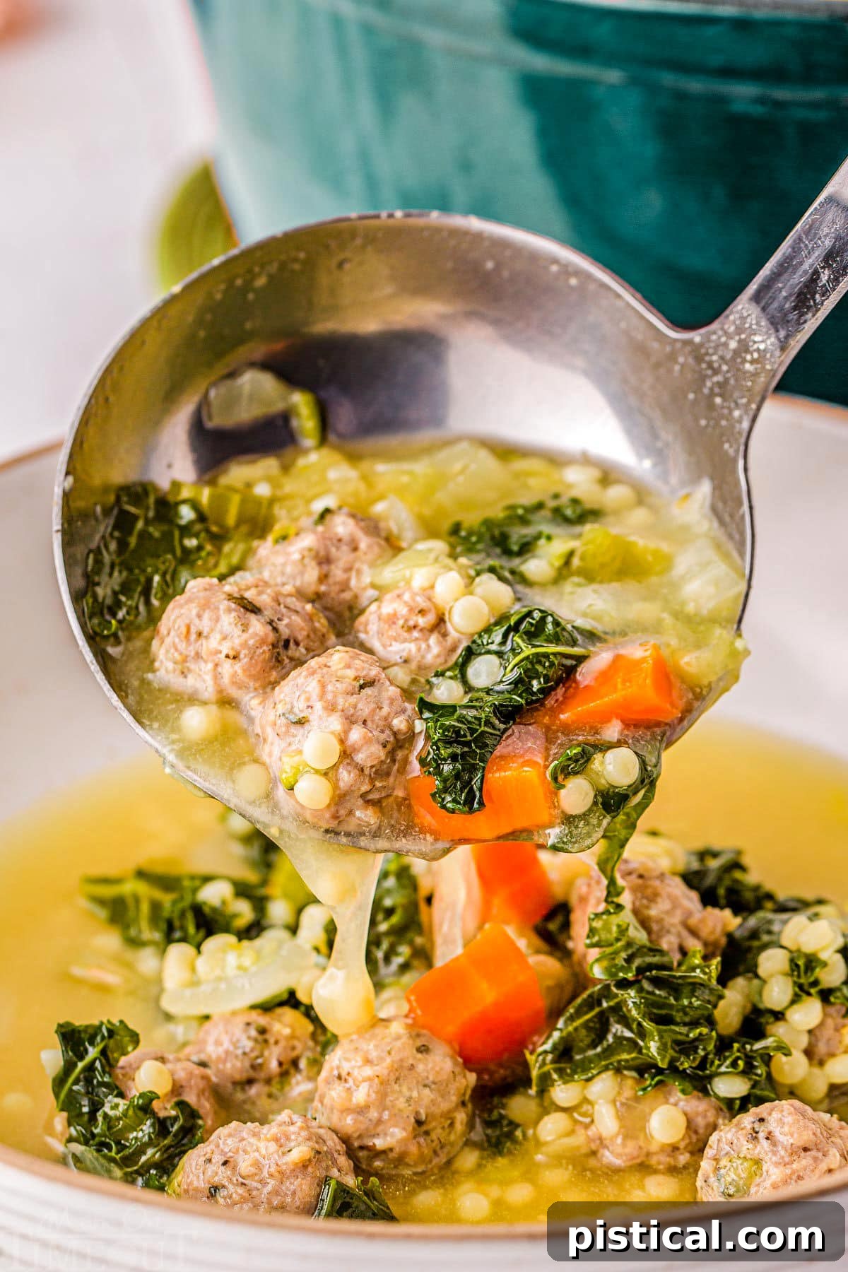Ladle of Italian Wedding Soup being ladled into a big bowl.