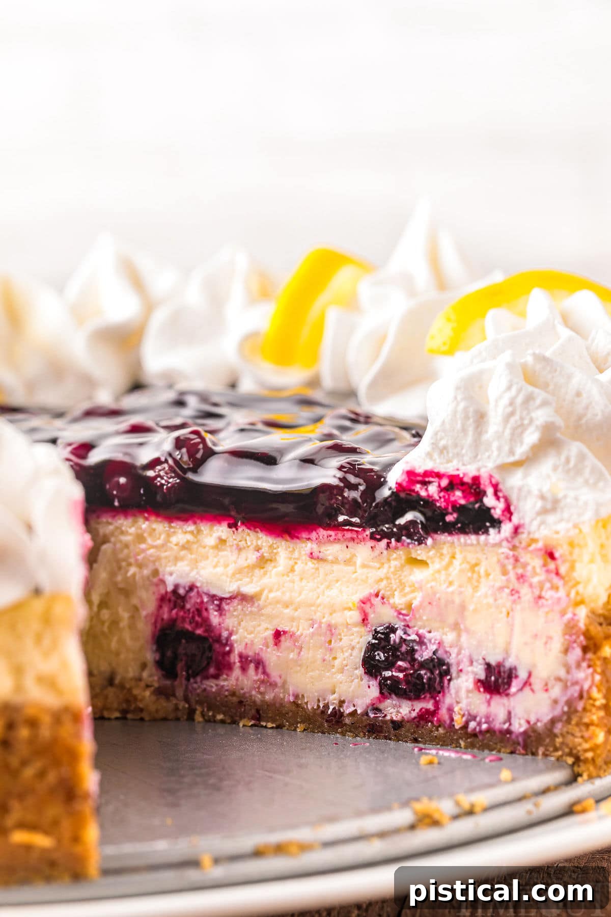Luscious Lemon Blueberry Cheesecake 3 lemon blueberry cheesecake with a piece removed.