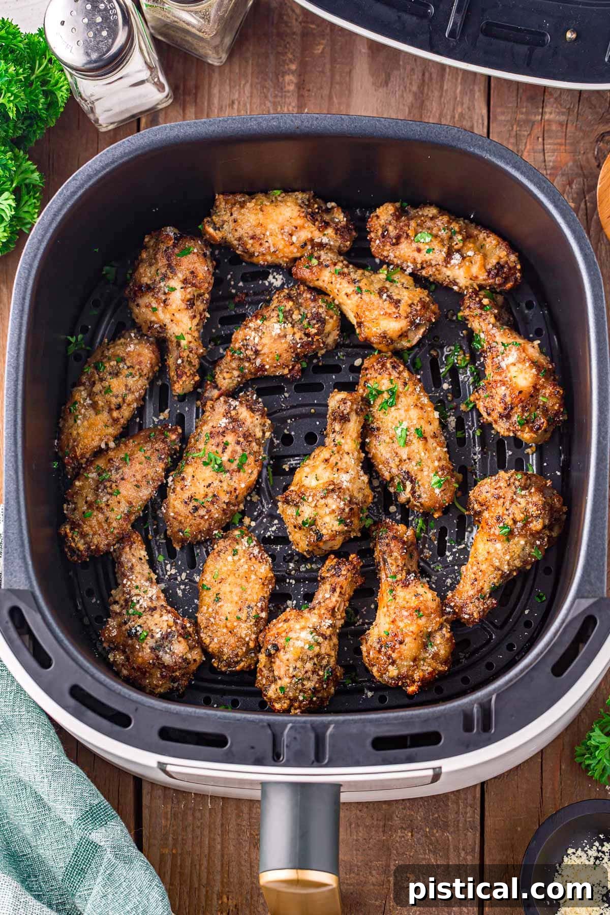 garlic parmesan wings in air fryer basket ready to be eaten.
