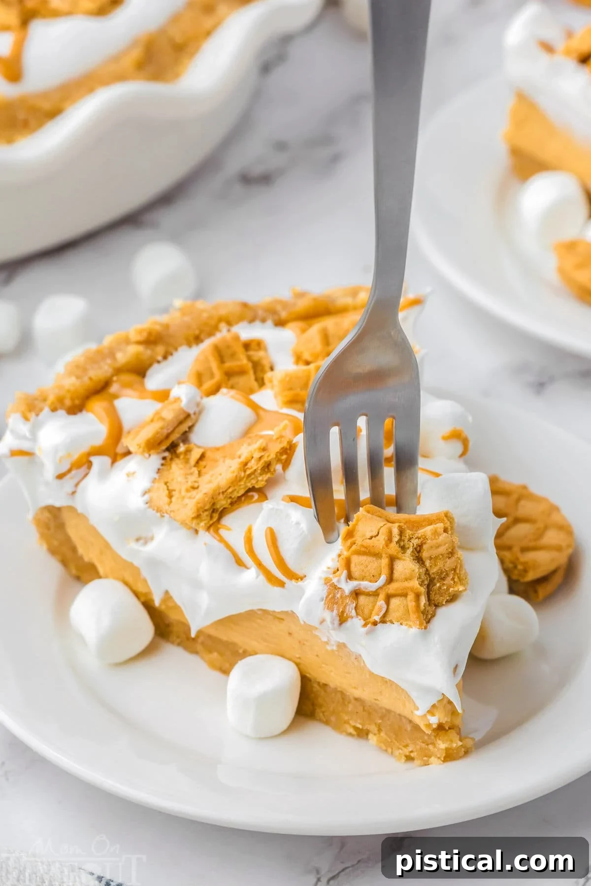 Piece of fluffernutter pie on a round white plate with a fork stuck into the pie. Pie has been topped with peanut butter cookies and marshmallows, showcasing its creamy texture and delightful garnishes.