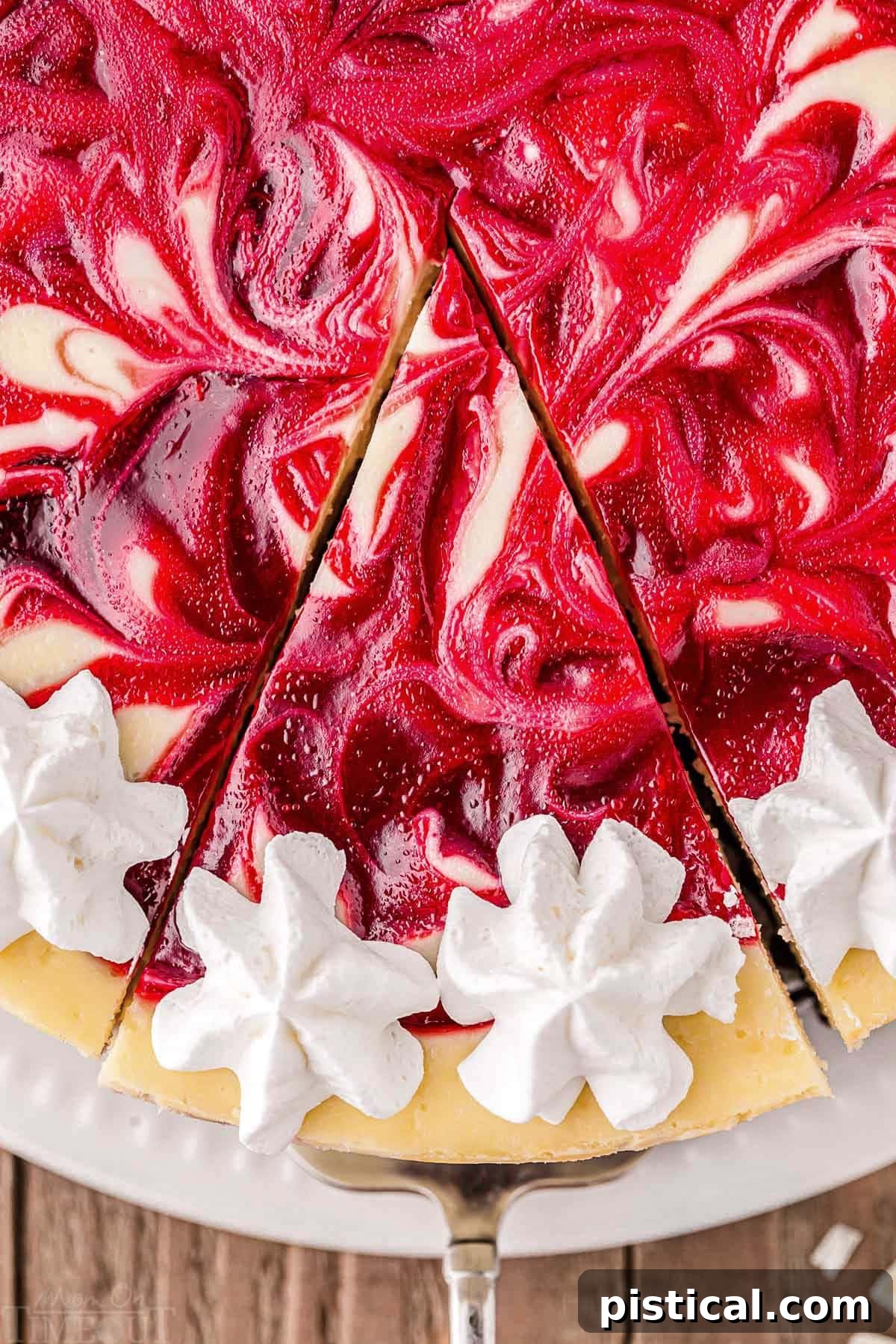 A top-down shot capturing a slice of cheesecake being carefully removed from the whole cake, revealing its layers and rich texture.