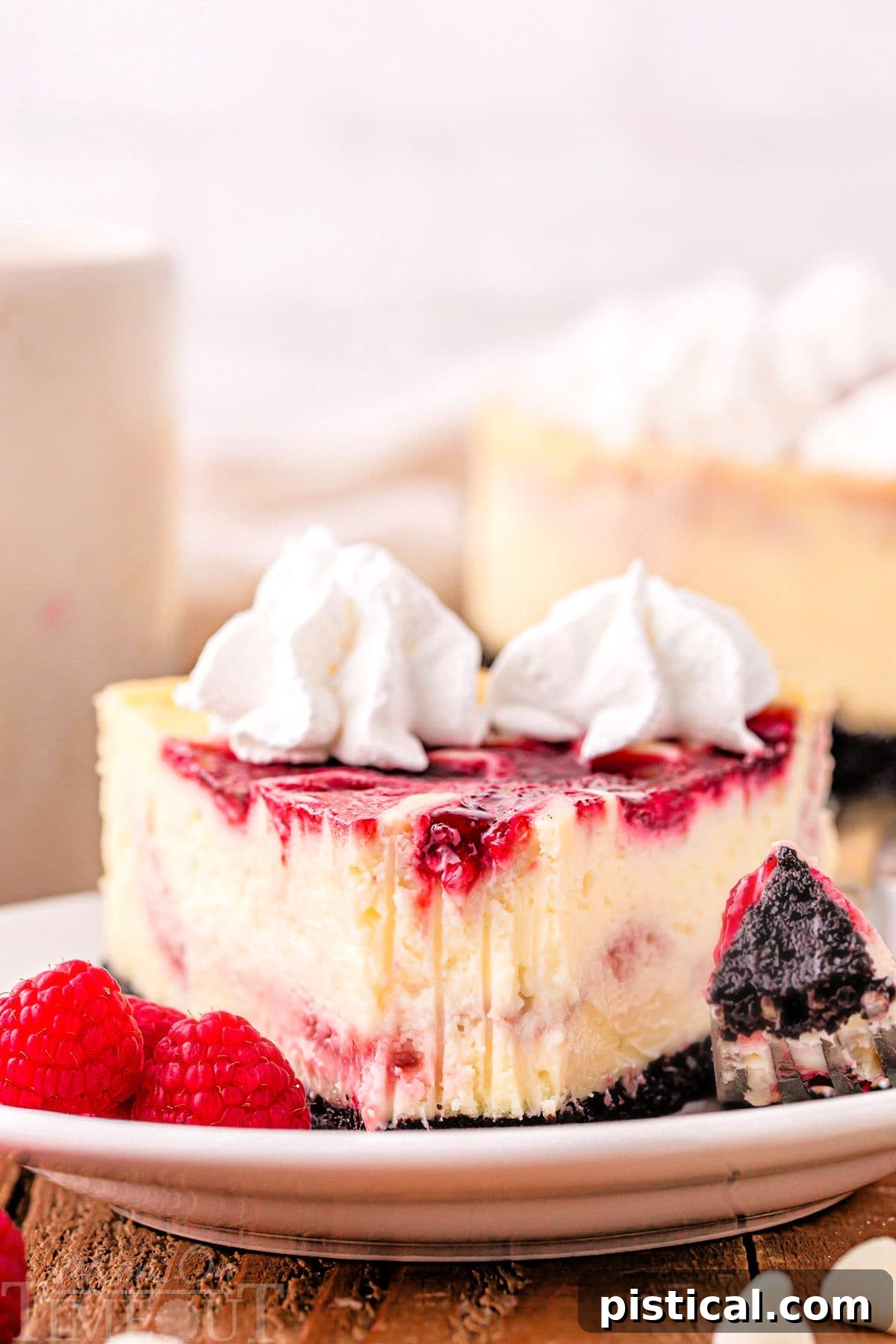 A close-up of a delectable piece of cheesecake with a single bite removed, showcasing the tines of a fork pressed into its creamy texture.