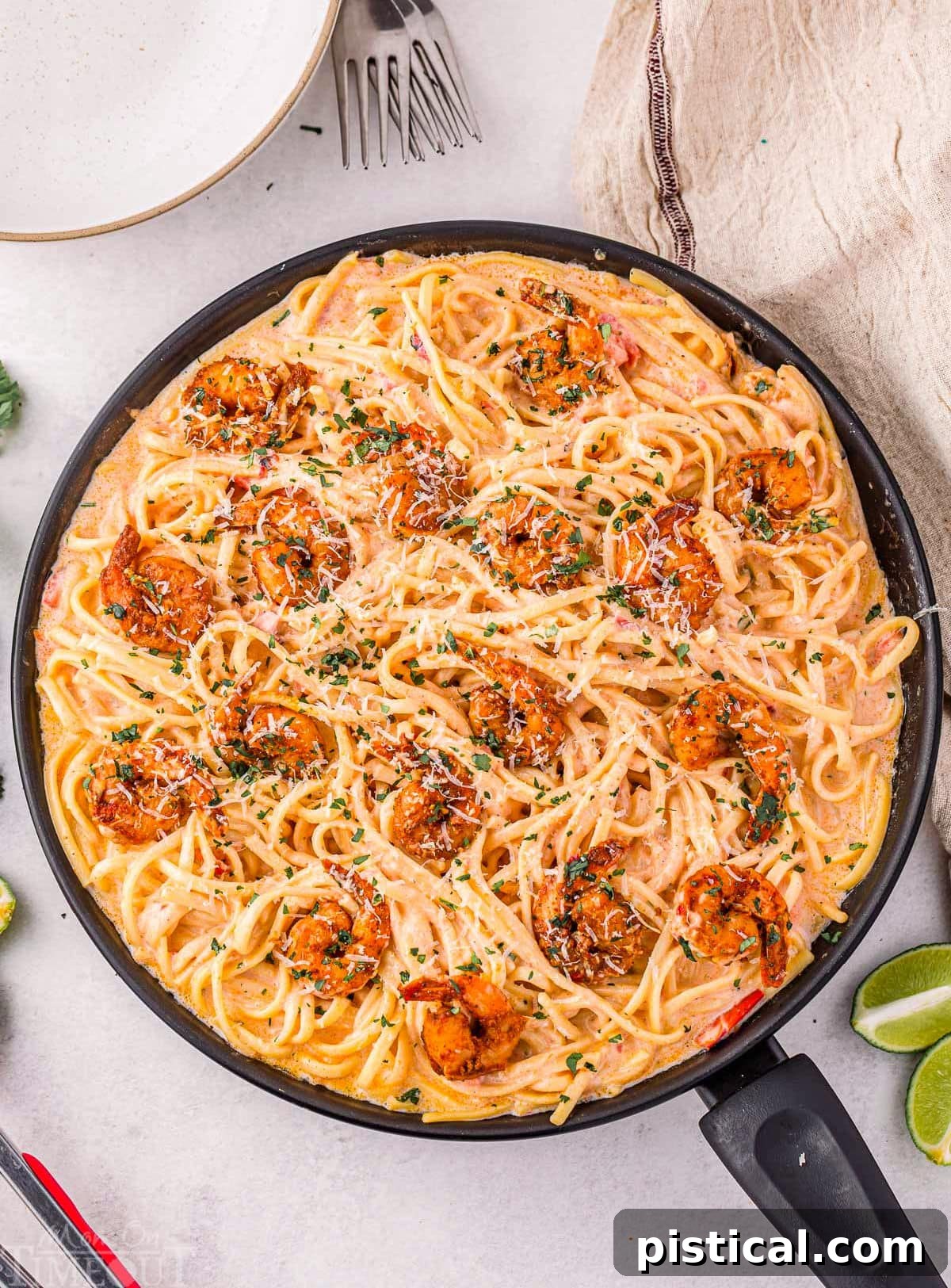 Overhead shot of creamy Cajun shrimp pasta recipe still in skillet garnished with fresh parsley and ready to serve.