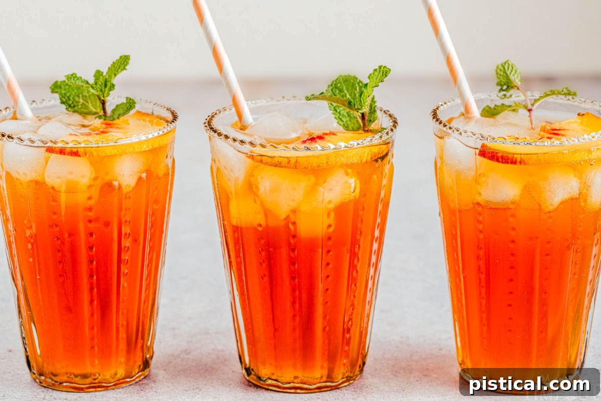 Sun-Kissed Peach Sip 7 Three glasses of peach iced tea arranged in a line, each garnished with fresh mint sprigs and thin slices of peach.