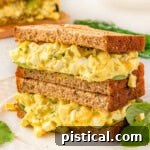 Two egg salad sandwiches stacked on top of each other.