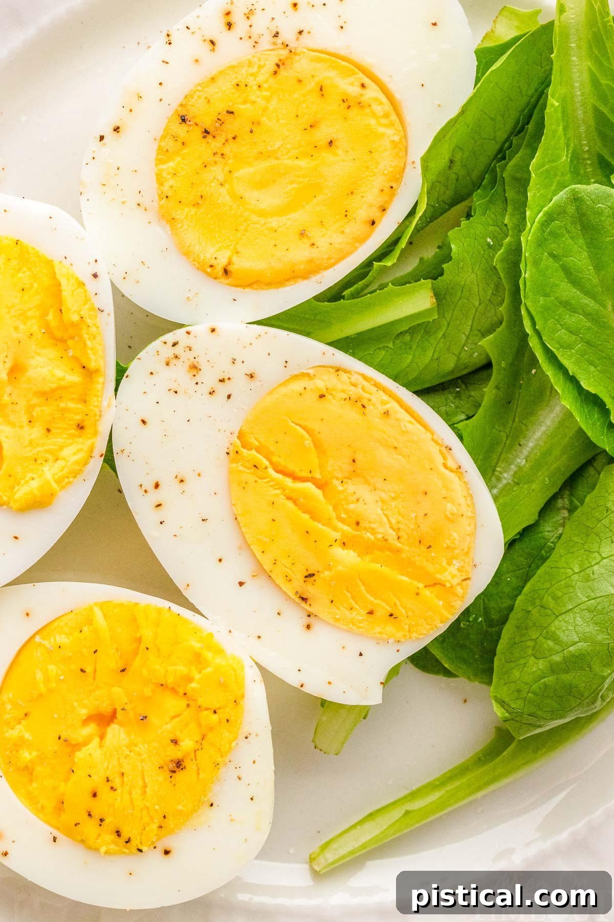 Freshly peeled hard-boiled eggs arranged on a bed of vibrant spinach leaves, showcasing their smooth texture.