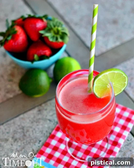 Strawberry Lime Agua Fresca served in a glass over ice, garnished with fresh lime slices and strawberries.