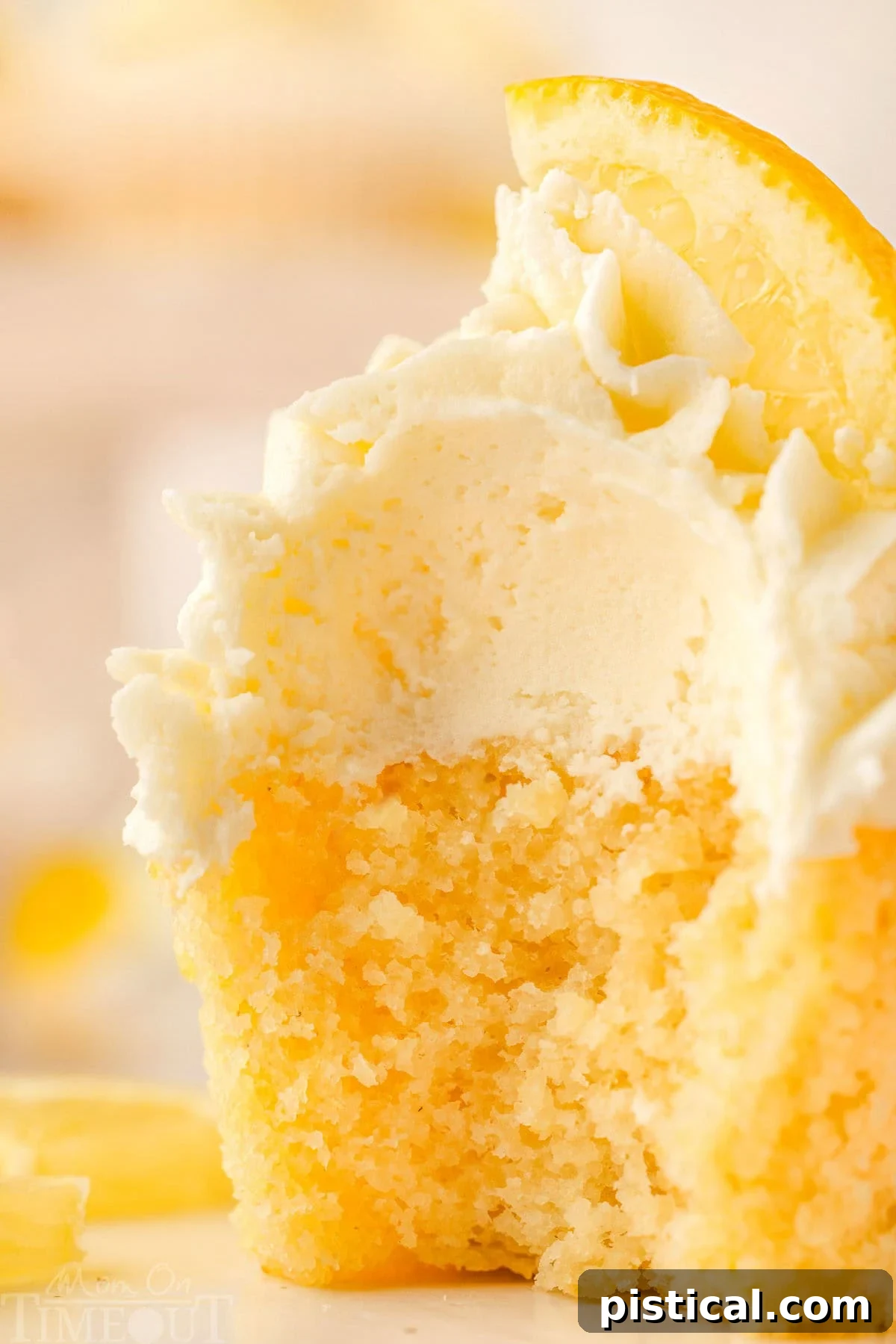 Zesty Lemon Delight Cupcakes 2 Close up of a lemon cupcake with a bite taken out of it.