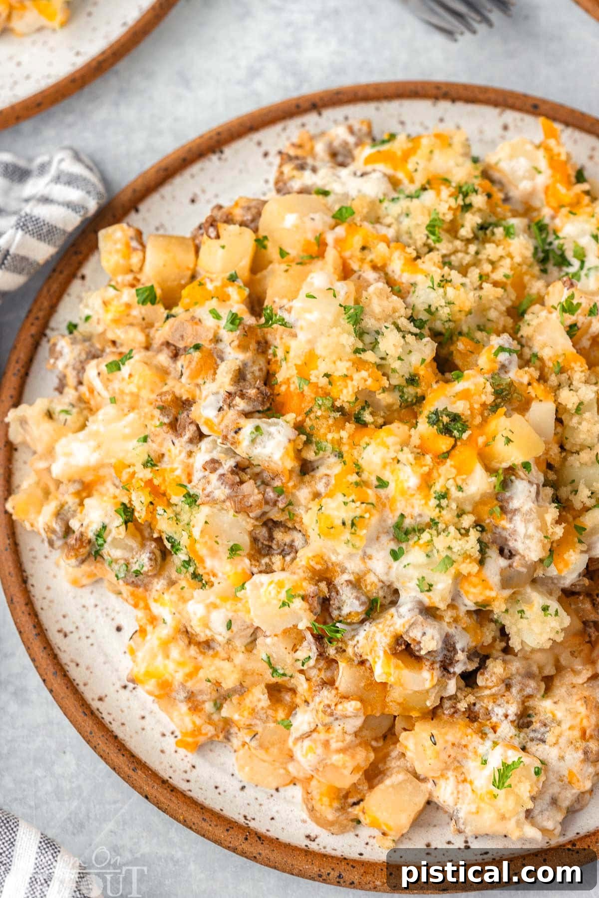 Top down view of a plated serving of easy ground beef casserole, garnished with fresh chopped parsley.