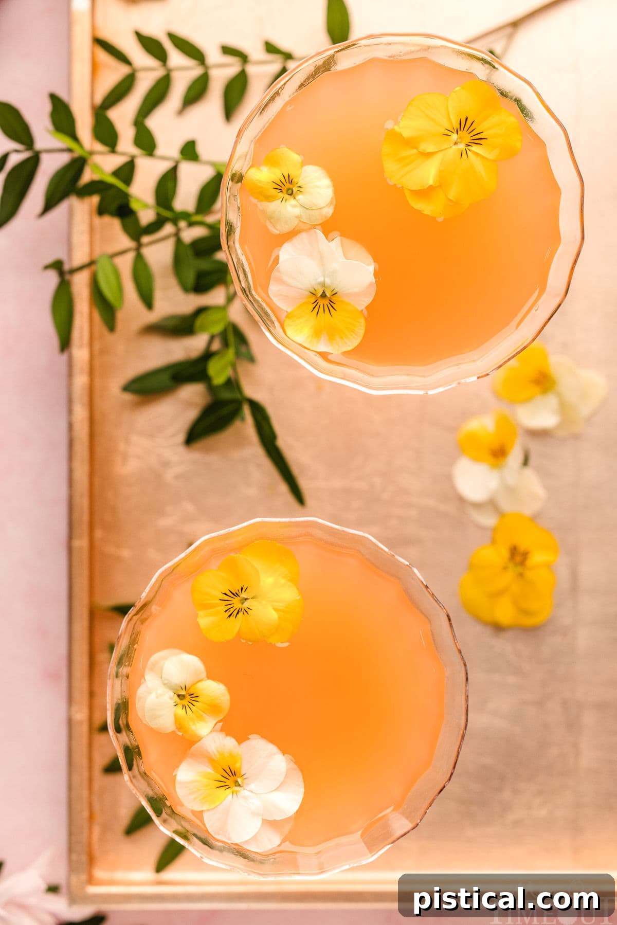 A Top down shot of french blonde cocktails in glasses on a metal tray.