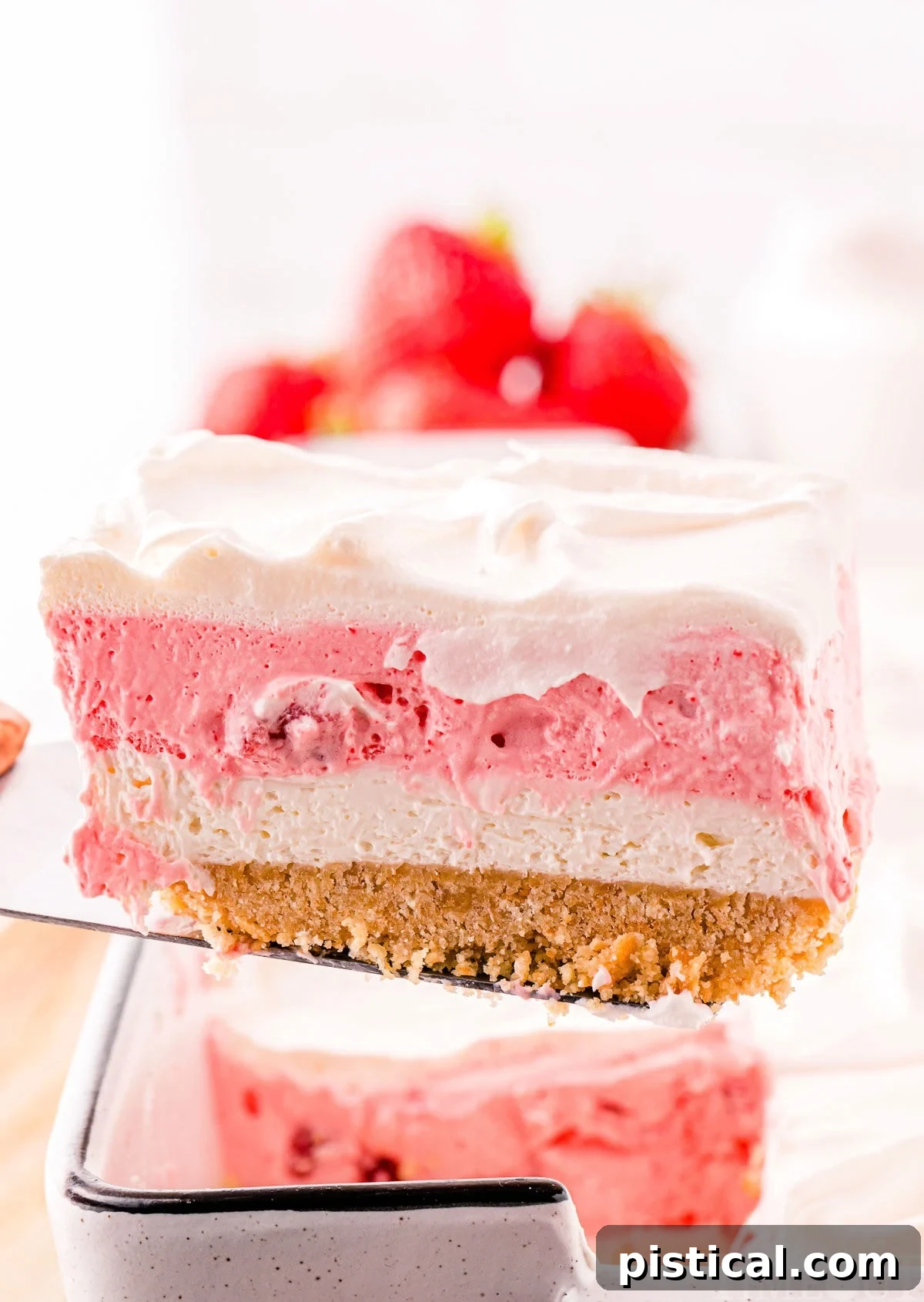 Layered Strawberry Dream 4 A spatula holding a slice of strawberry lasagna.