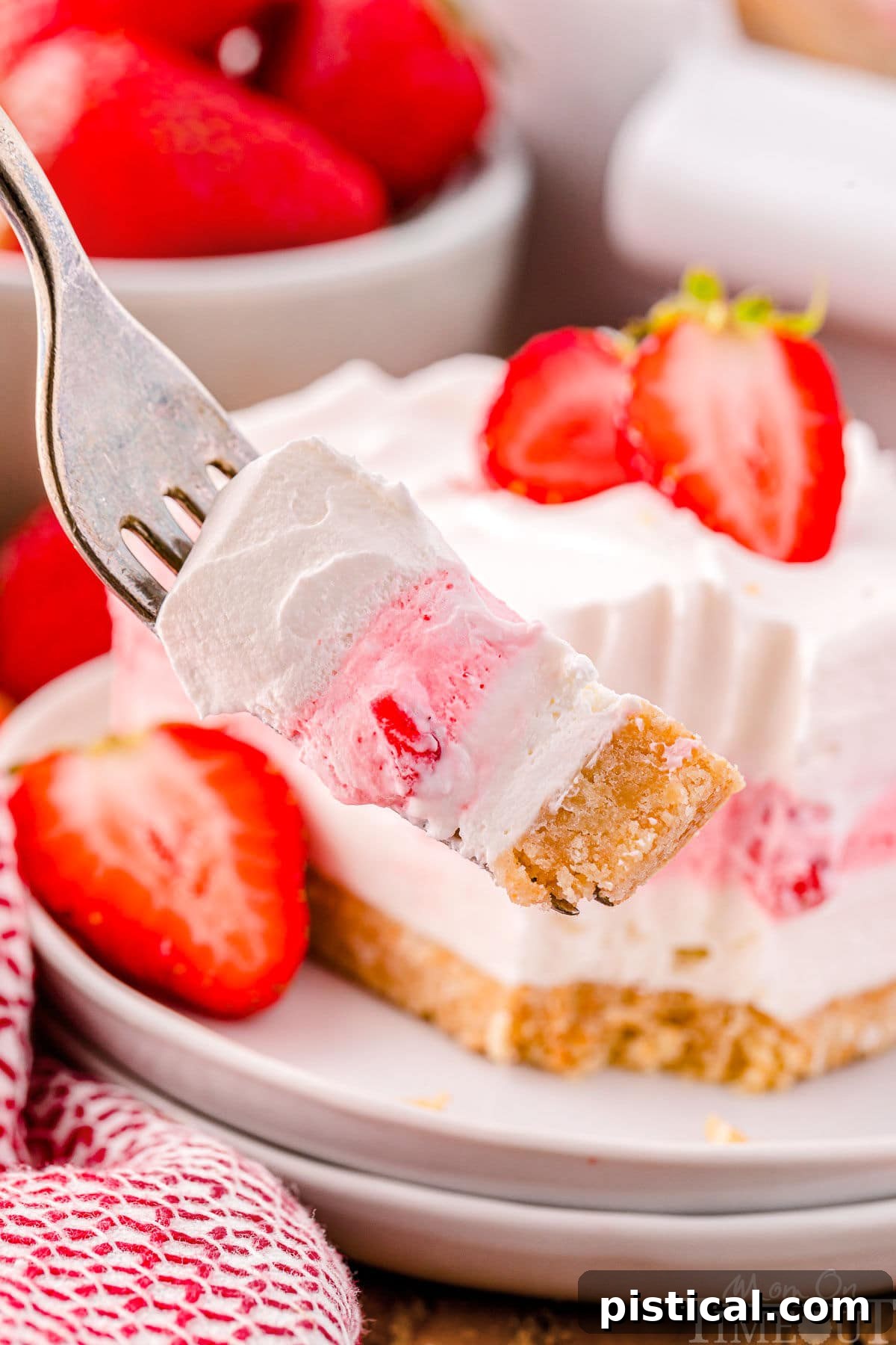 Layered Strawberry Dream 6 A fork with a bite of strawberry lasagna on it.