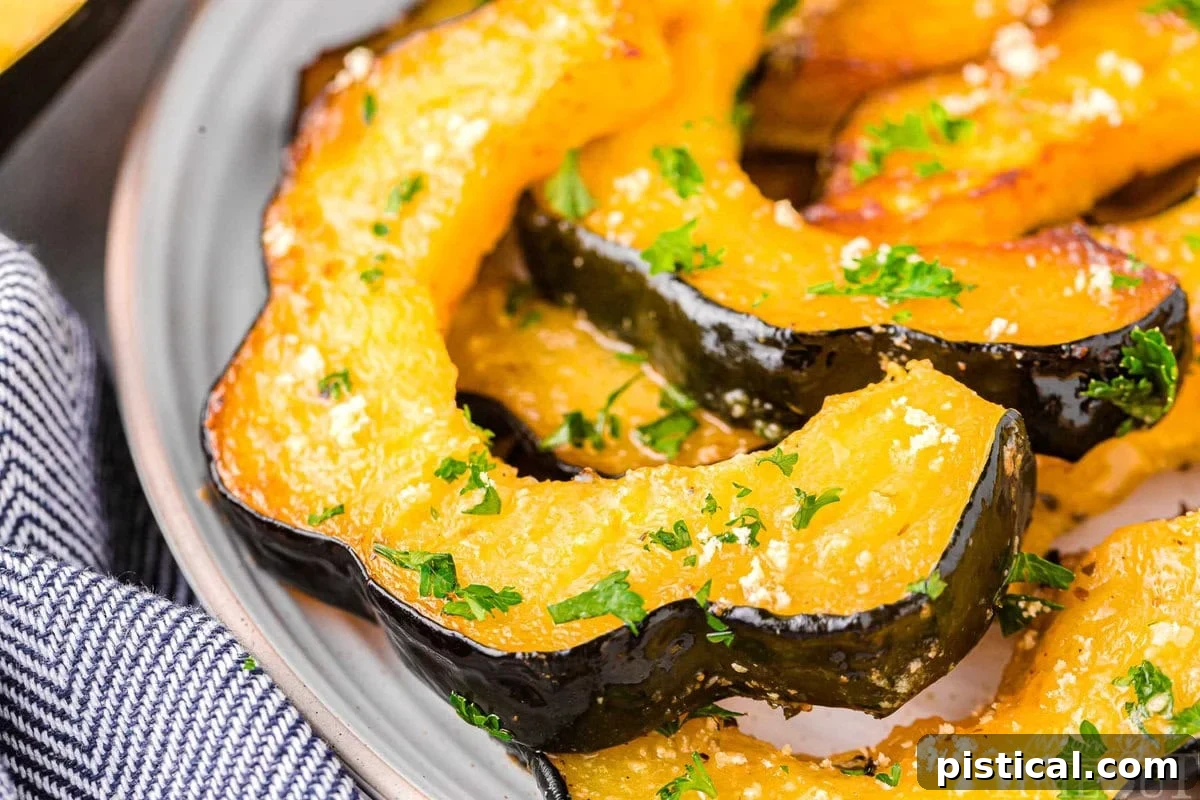 Slices of perfectly roasted acorn squash served on a white plate, garnished lightly.