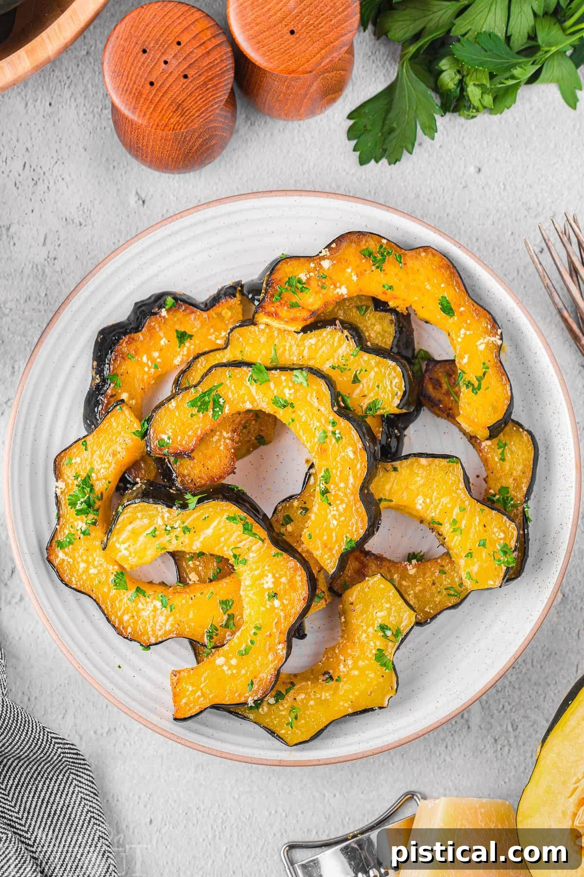 Top down view of a plate of roast acorn squash ready to be enjoyed, garnished with fresh herbs.