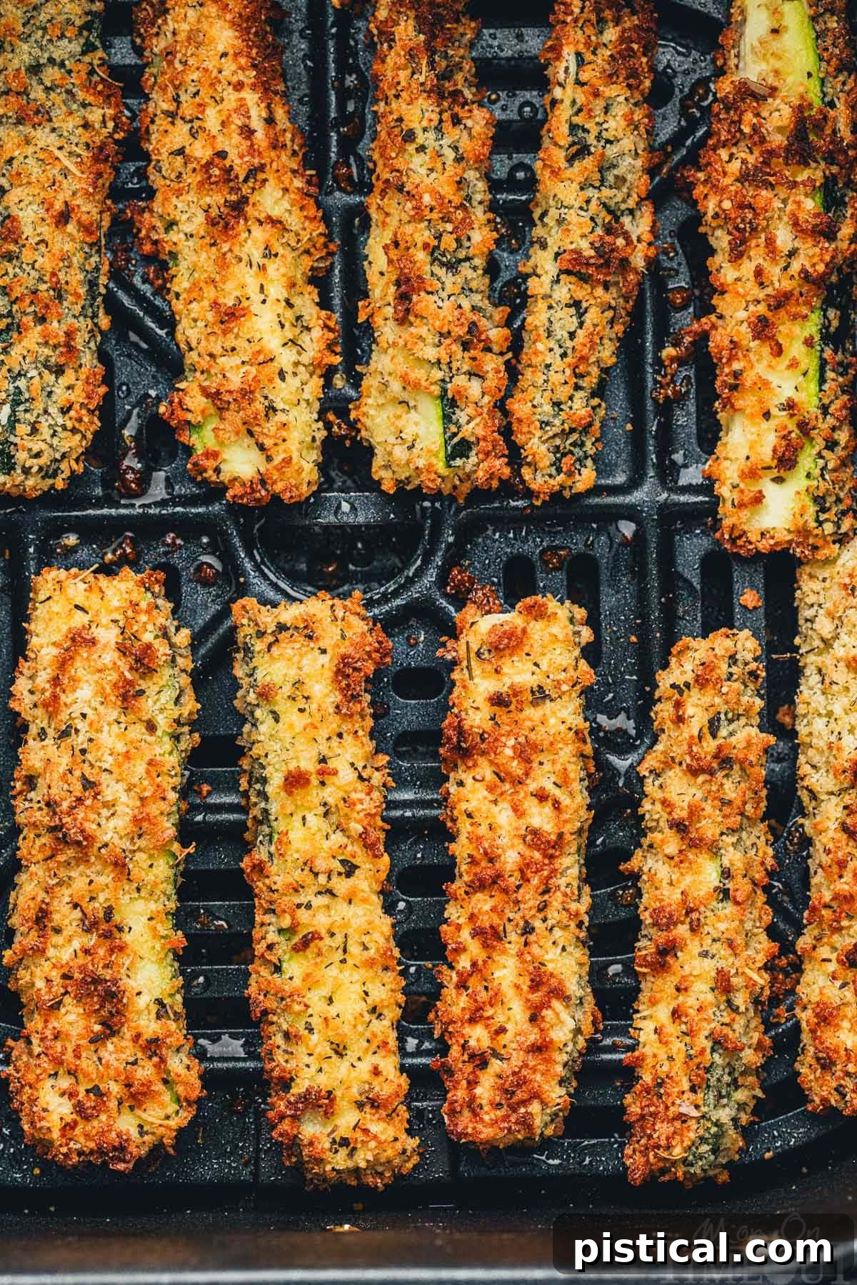 Top down view of zucchini fries cooked in an air fryer, golden brown and perfectly crisp, ready to be served as a delicious and healthy snack or side dish.