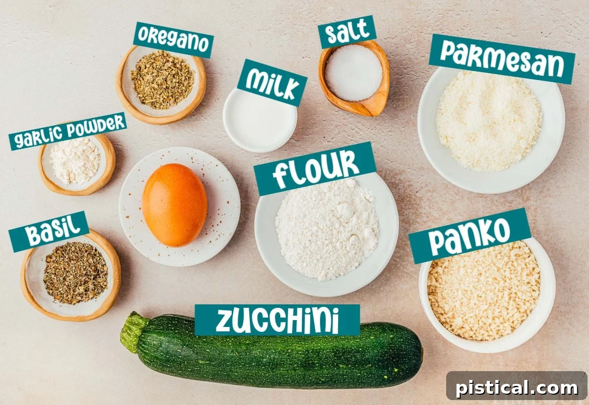 Ingredients for air fryer zucchini all laid out and ready to be used in the recipe, including zucchini, flour, eggs, panko, Parmesan, and a variety of seasonings.
