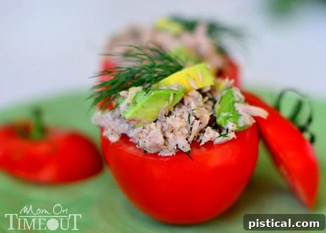 Close-up view of a Tuna and Avocado Stuffed Tomato, highlighting the creamy, fresh, and healthy filling within a ripe tomato.