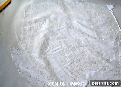 Applying glue to half of a wax paper sheet for the Earth craft