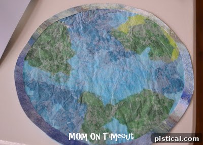Trimming excess wax paper from the finished stained glass Earth craft
