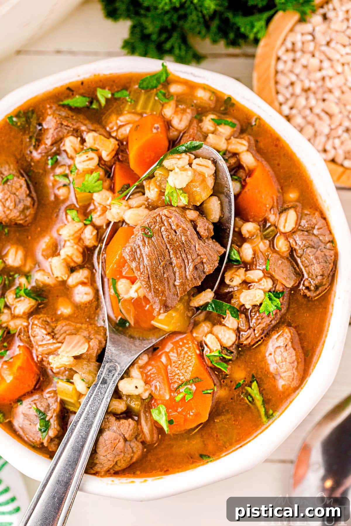 Hearty Beef Barley Stew 4 A top down view of a spoon in a bowl of beef and barley soup.