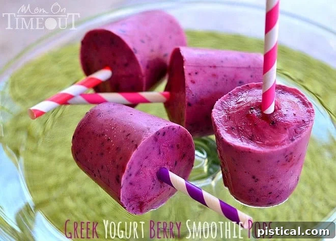 Close-up of a child's hand holding a vibrant Greek Yogurt Berry Smoothie Pop, highlighting its delicious and kid-friendly nature.