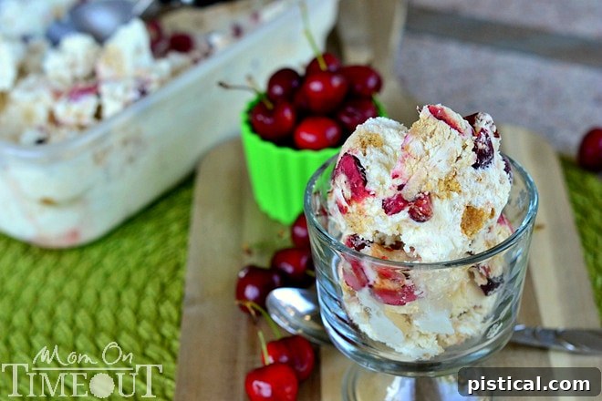 Two scoops of Cherry Cheesecake Magic Ice Cream, garnished with fresh cherries, served in a clear glass bowl, showcasing its beautiful layers.