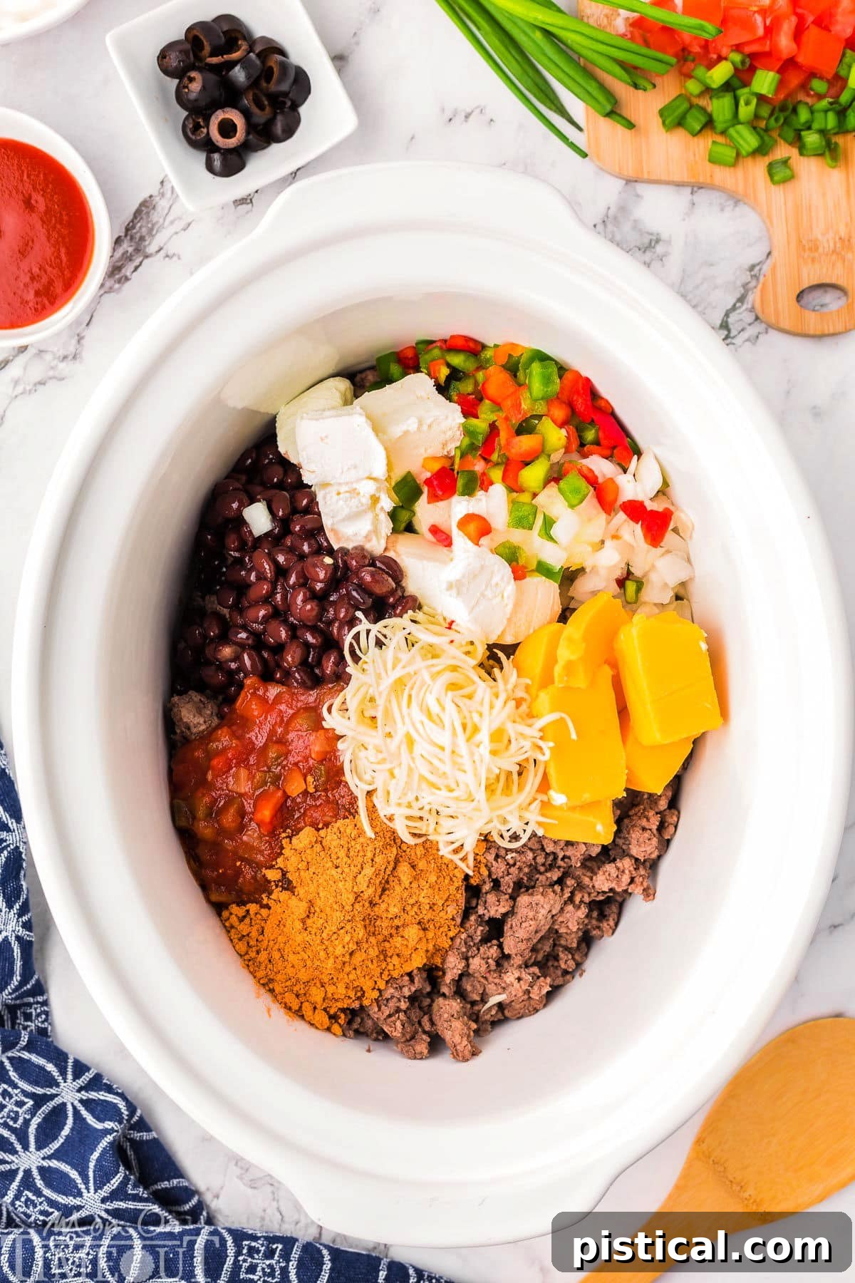 Warm & Cheesy Slow Cooker Taco Dip 3 Crockpot taco dip ingredients in a slow cooker.