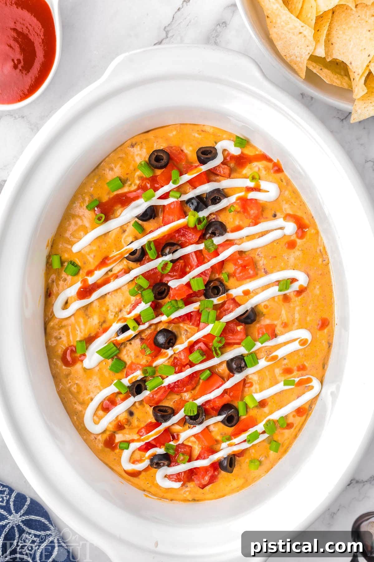 Warm & Cheesy Slow Cooker Taco Dip 8 Top down view of crockpot taco dip in a white crockpot liner.