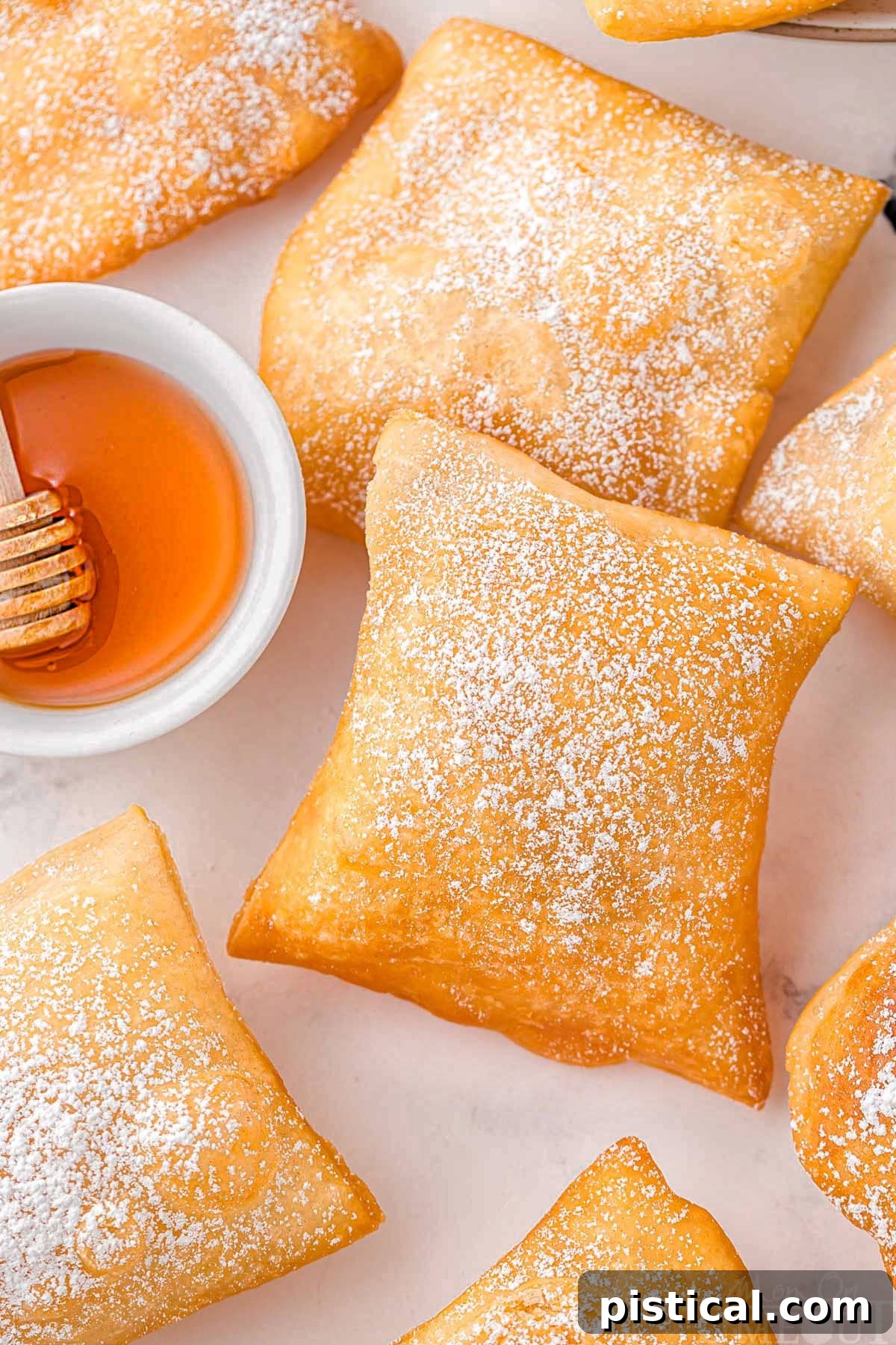 A top down shot of sopapillas on a white surface.