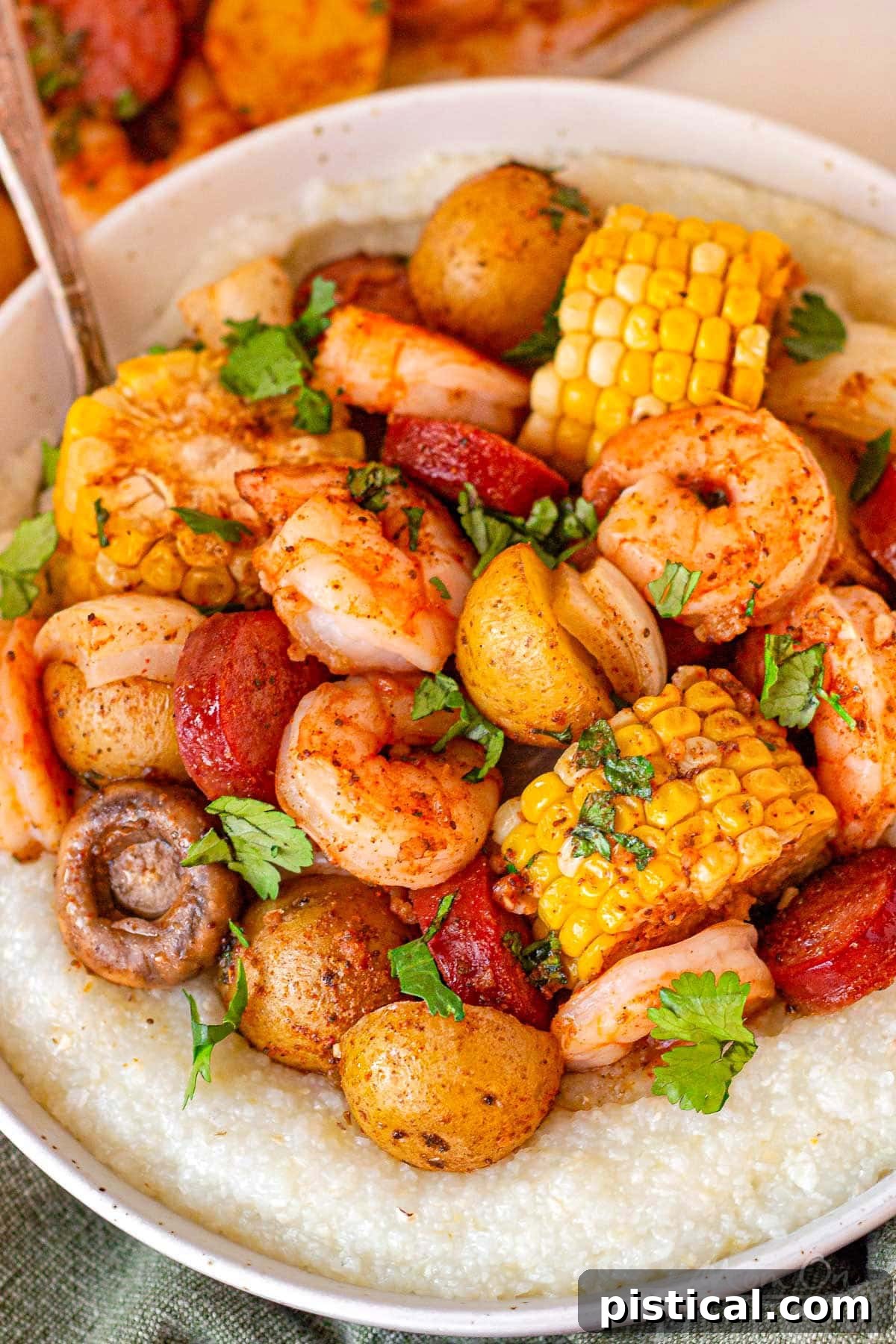 Close up of the old bay shrimp boil in a bowl with grits and garnished with parsley.