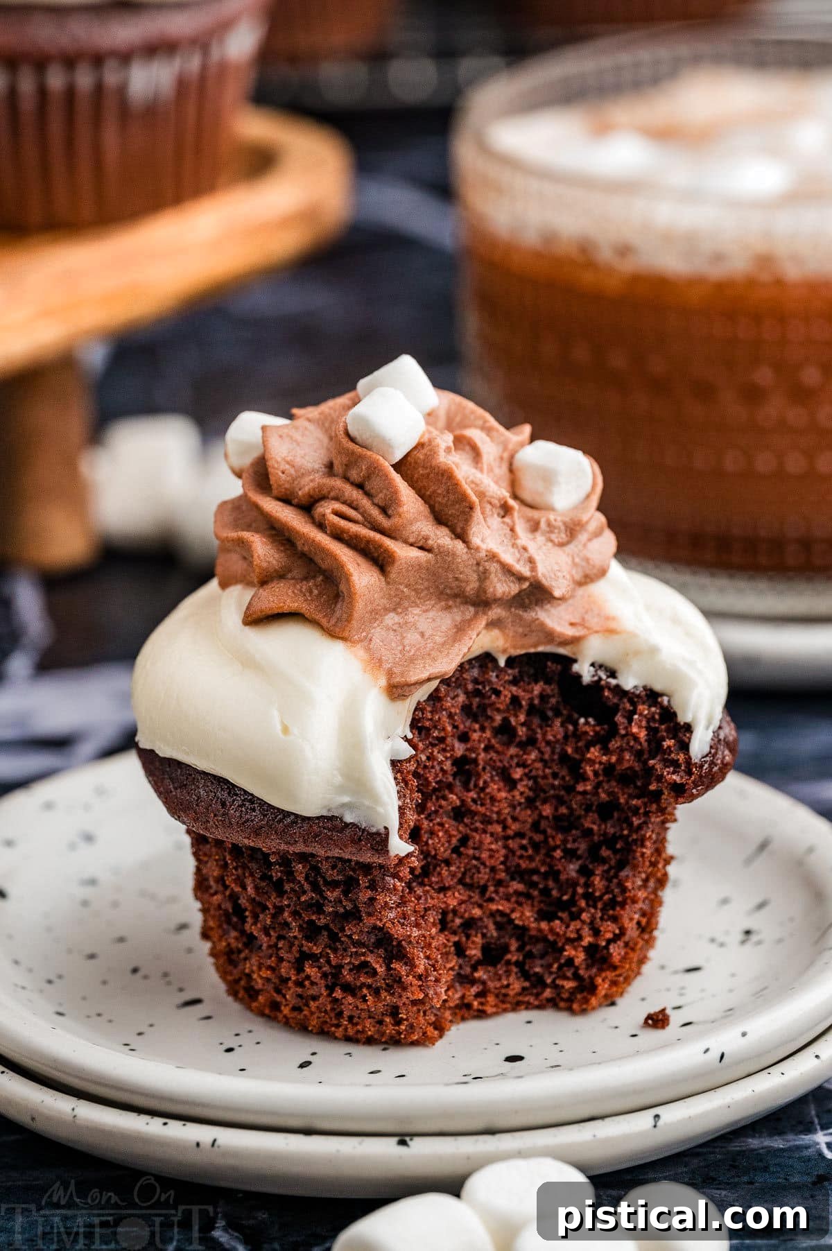 Velvet Hot Chocolate Cupcakes 7 A hot chocolate cupcake on a white plate with a bite taken out, revealing the moist interior.