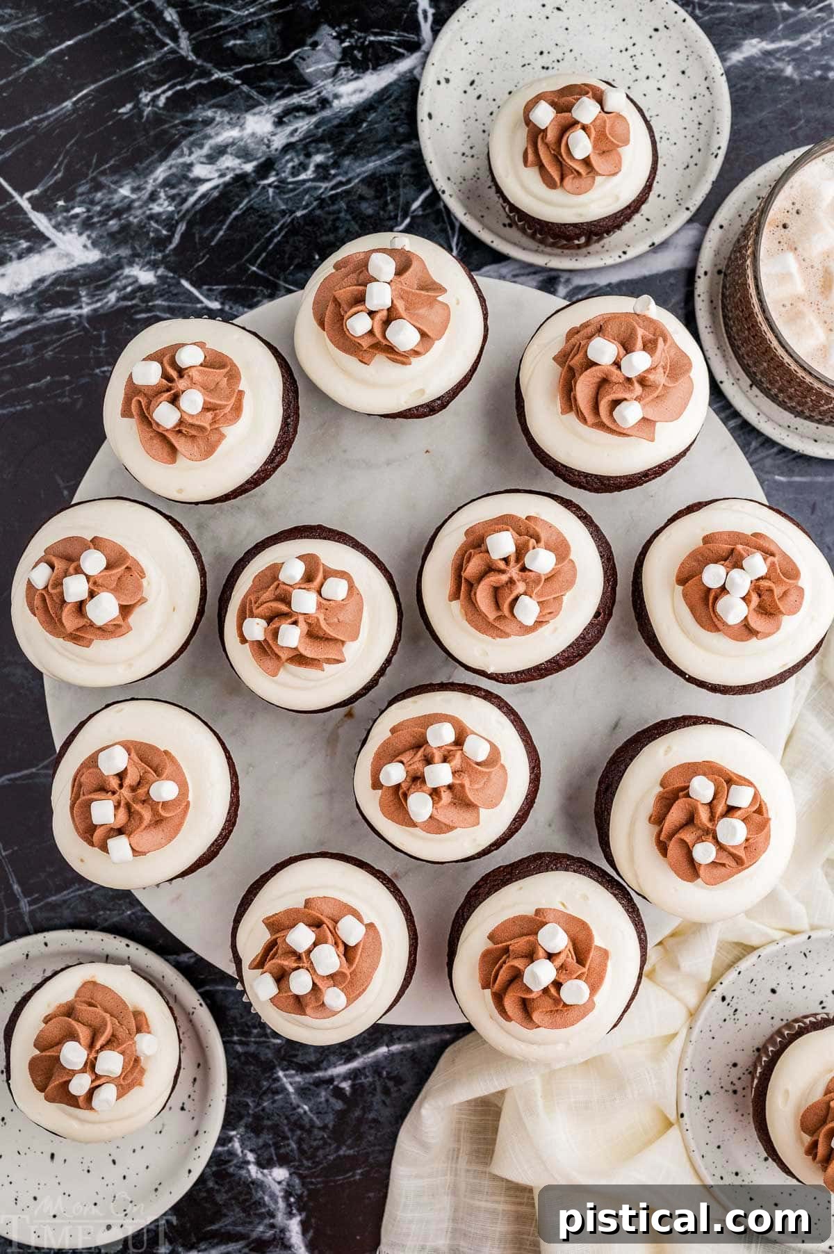 Velvet Hot Chocolate Cupcakes 9 A top-down view of hot chocolate cupcakes arranged on a round marble serving tray.