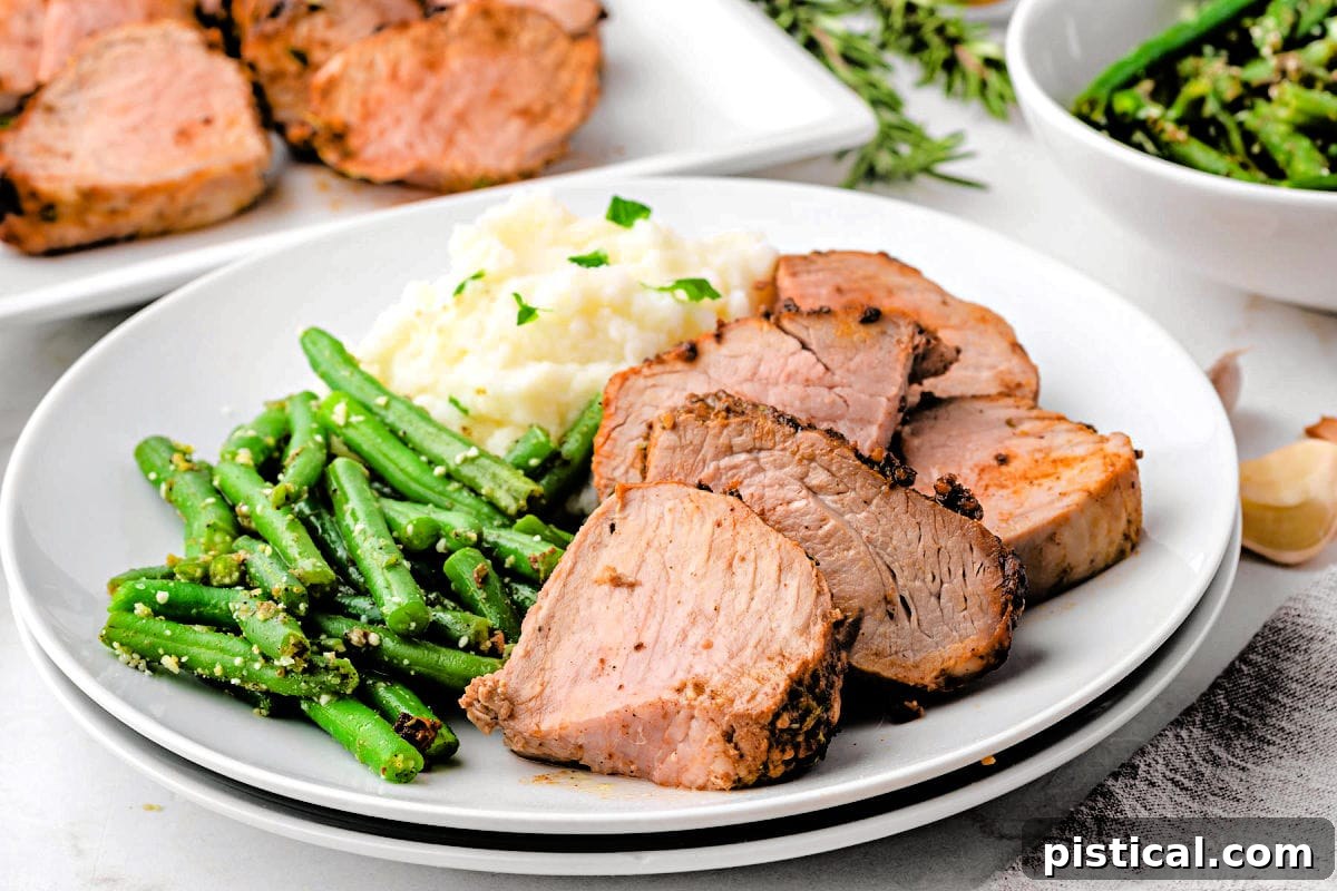 Dinner plate with air fryer pork tenderloin cut into medallions, green beans and mashed potatoes.