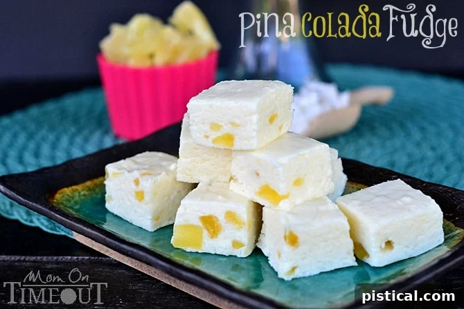 Pina Colada Fudge squares artfully arranged, highlighting the golden pineapple bits and coconut flakes, inviting viewers to indulge in this tropical treat.