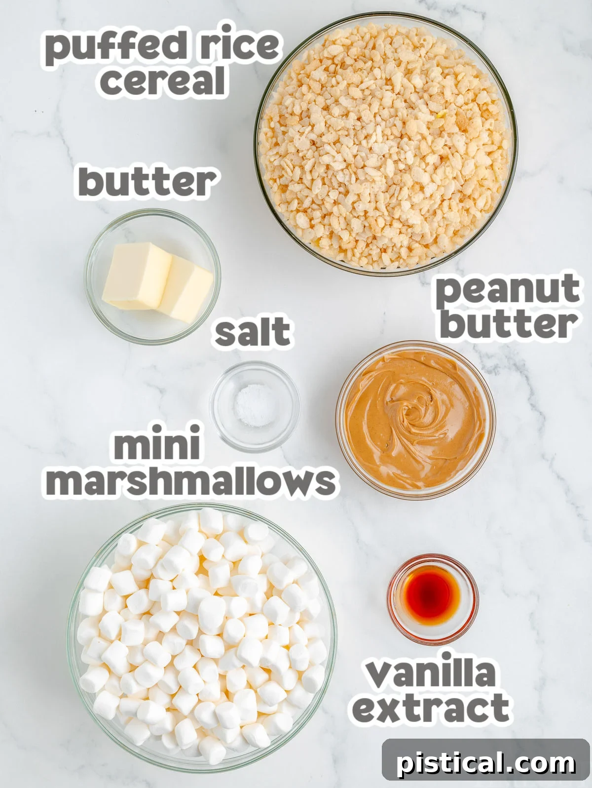 Overhead shot of peanut butter rice krispie treat ingredients measured out into shallow bowls ready to be used in the recipe, including marshmallows, peanut butter, and rice cereal.