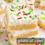 Three Christmas Sugar Cookie Bars in a stack with more bars in the background.
