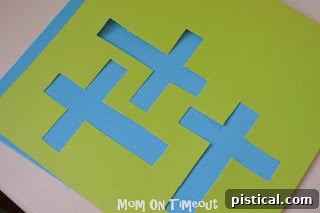 Printed cross templates being cut out with a craft knife for precision.