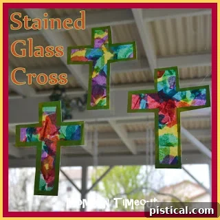 Two finished stained glass crosses displayed on a sunlit window, showcasing vibrant colors.