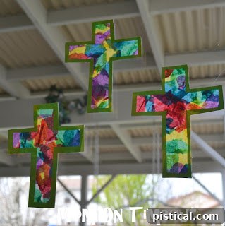 A close-up view of a Stained Glass Cross craft glowing in a window.