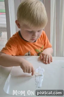A roll of wax paper being unrolled to twice the width of a cross template.