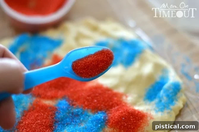 Dough being rolled up with red and blue sprinkles, demonstrating the sparkler cookie technique.