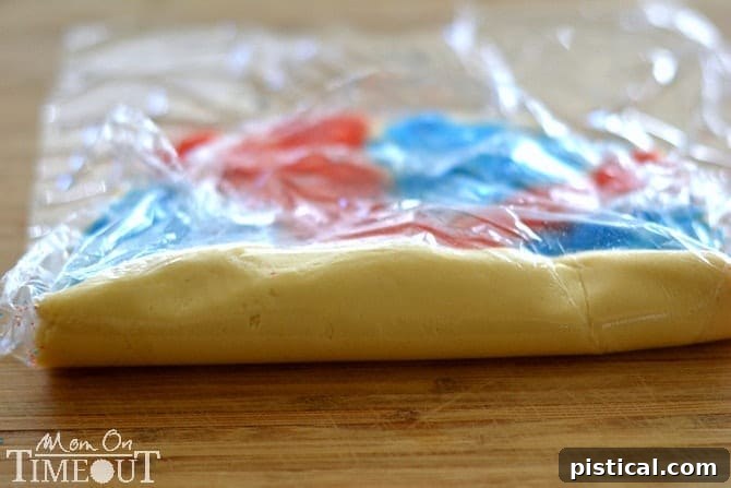 Close-up of a chilled dough log being sliced into individual Red, White, and Blue Sparkler Cookies.