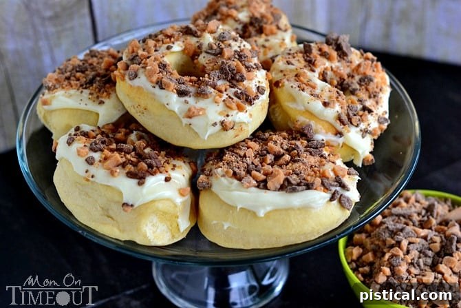 A close-up of a homemade baked Heath doughnut with creamy cream cheese frosting and Heath candy crumbles.