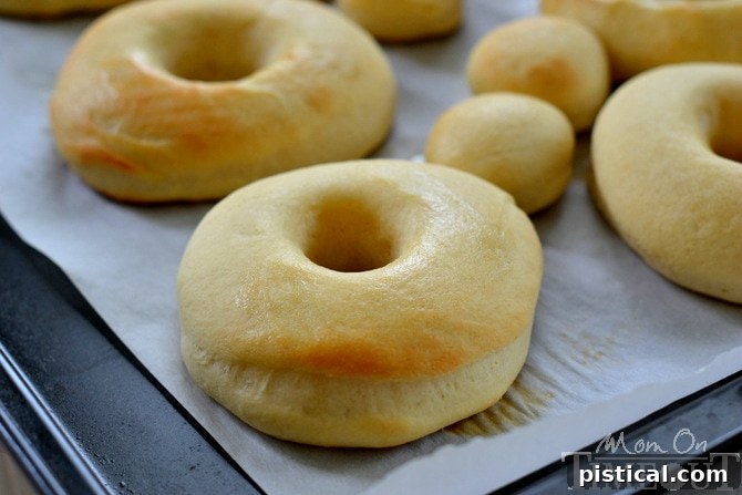 A tray of freshly baked, golden brown Heath doughnuts cooling before being frosted.