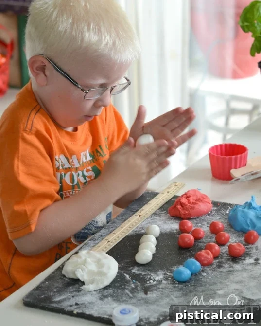 Stars and Stripes Peppermint Delights 2 A young boy, Reece, enthusiastically rolling candy dough into small balls on a floured surface, participating in making the patriotic peppermint patties.