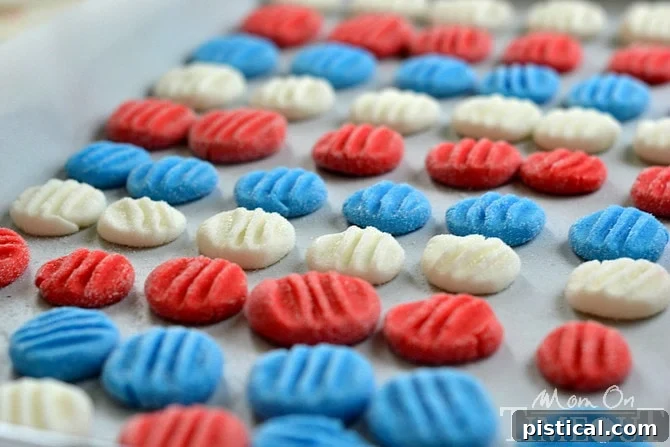 Homemade Lemon-Flavored Red, White, and Blue Patties: A Unique Patriotic Treat! Three vibrant red, white, and blue lemon-flavored patriotic patties artfully arranged on a white background, showcasing their attractive colors and smooth texture.