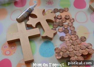 Wooden cross freshly painted with shimmering copper metallic paint, drying on a protective surface
